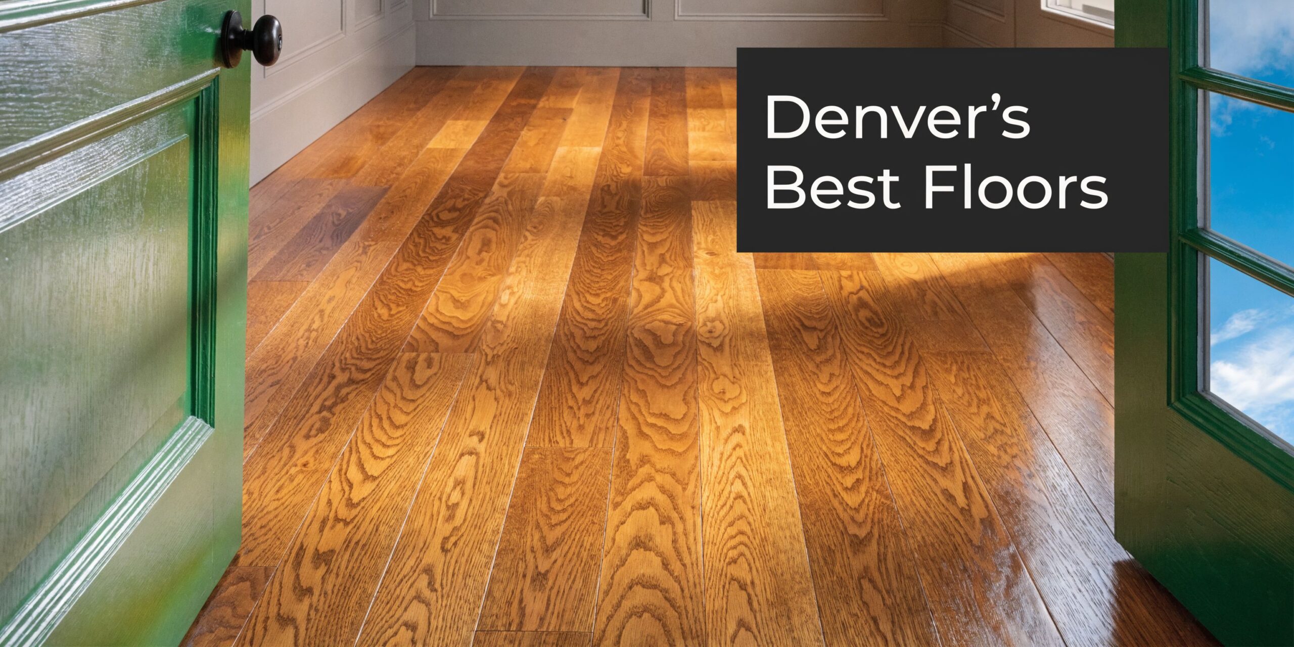 A view of polished hardwood flooring inside a room with a green door open to daylight.