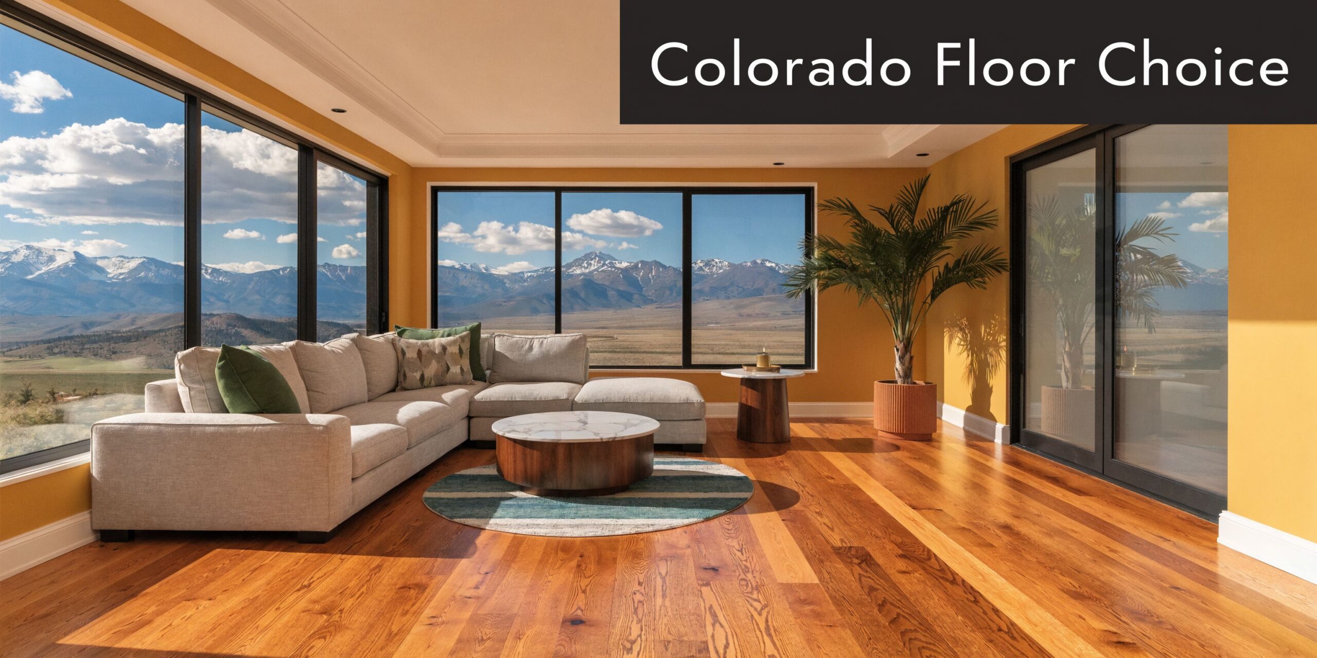 A luxurious living room featuring highland hardwood flooring with a mountain view through large floor-to-ceiling windows.