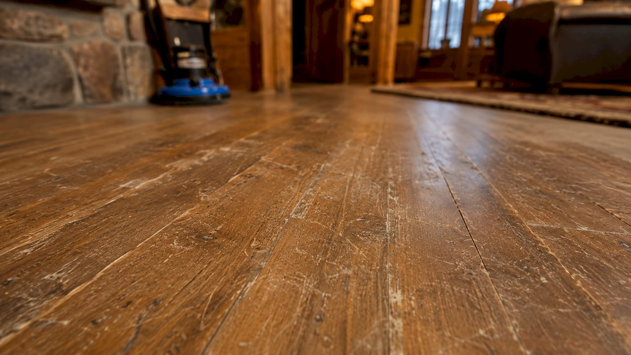 Close-up of worn hardwood floor with scratches