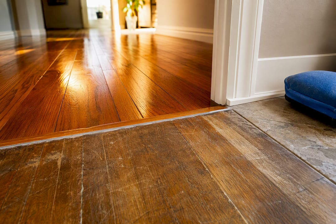Refinished hardwood beside sealed flooring transition
