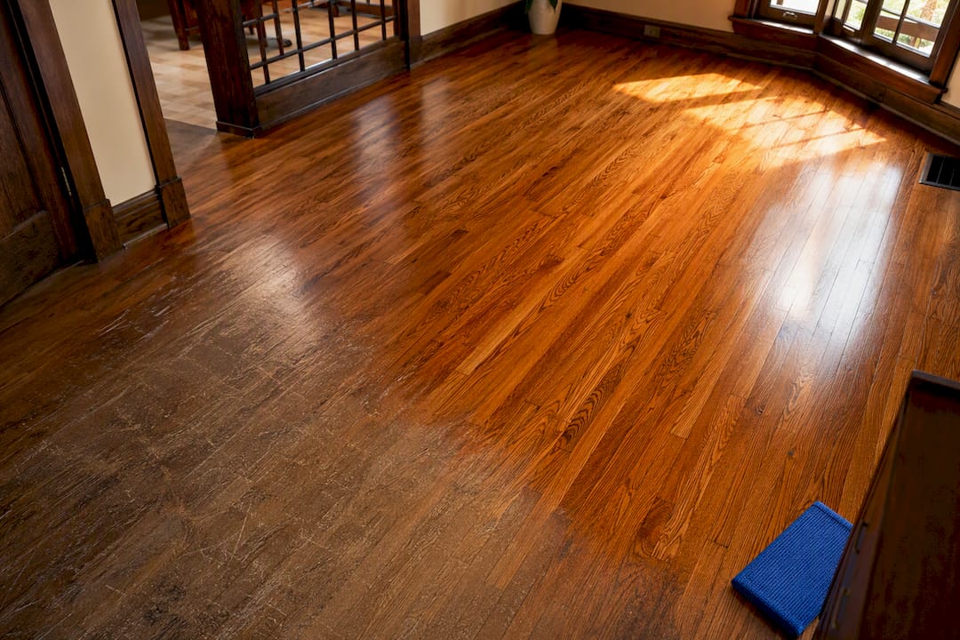 Refinished hardwood beside worn scratched flooring